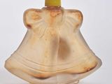 a small glass bottle with a bell on top of it