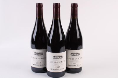 three bottles of red wine are lined up on a white surface