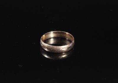 gros plan d'une bague en argent sur une surface noire