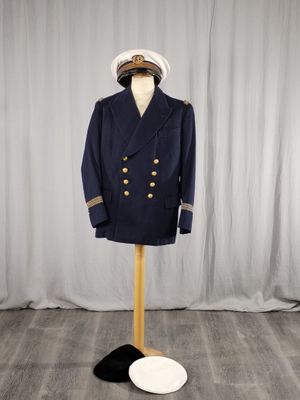 un costume et un chapeau posés sur un mannequin devant un rideau