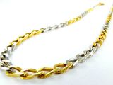 un gros plan d'un collier en or et en argent posé sur une surface blanche