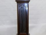 une horloge de parquet qui se trouve au milieu d'une pièce