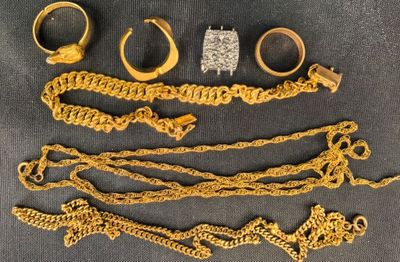 Plusieurs bagues et bracelets en or sont disposés sur une table