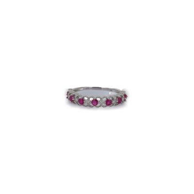 un gros plan d'une bague ornée de pierres roses sur fond blanc