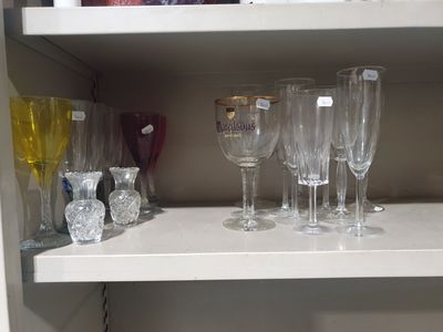 many wine glasses sitting on a shelf in a cabinet