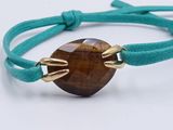 a close up of a bracelet with a tiger eye stone on it