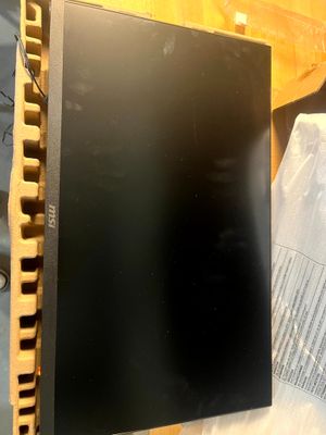 un écran d'ordinateur noir posé sur une table en bois