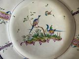 a plate with birds painted on it sitting on a table
