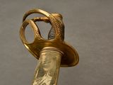 a close up of a gold colored sword with a bird on it