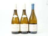 trois bouteilles de vin posées les unes à côté des autres sur une surface blanche