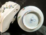 a small white vase with a blue and yellow design on it