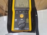 yellow and black digital multimeter sitting on top of a black case