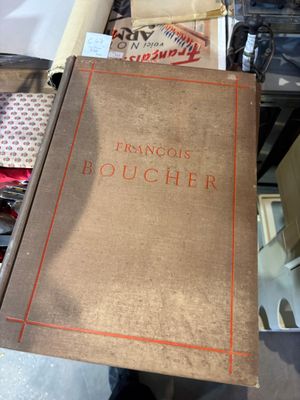 un vieux livre posé sur une table à côté d'une pile de livres