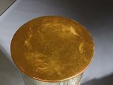 a silver vase with a gold top sitting on top of a table