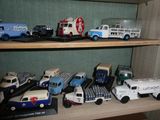 de nombreuses petites voitures et camions sur une étagère dans une pièce