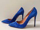 blue sued high heel pumps with a pointed toe on a white surface