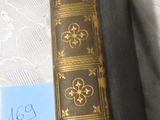 un très vieux livre posé sur une table, sur lequel est collée une étiquette bleue