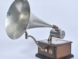 a silver and black gramphone on a wooden stand
