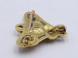 an image of a close up of a gold plated brooch