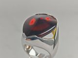 a close up of a ring with a red stone on it