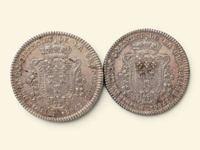 deux pièces d'argent, l'une ornée d'une couronne et l'autre d'un blason