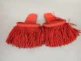 a pair of red sandals with fringes on them