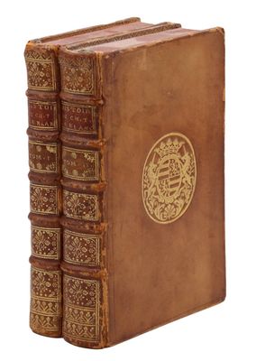 un vieux livre orné d'un emblème doré sur la couverture
