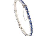 un gros plan d'un bracelet orné de pierres bleues sur fond blanc