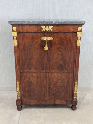 a wooden chest of drawers with a marble top