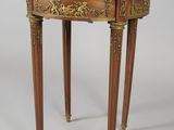 une petite table avec un plateau en marbre et des pieds en bois