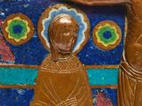 a gold statue of jesus and a woman on a blue background