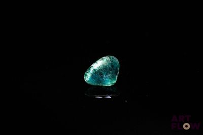 gros plan d'un diamant vert sur une surface noire