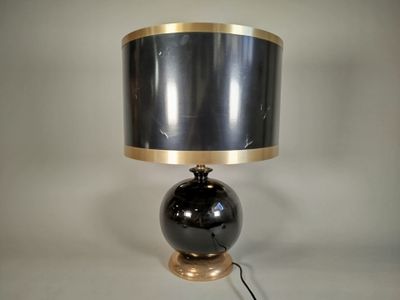 une lampe noire et dorée, munie d'un abat-jour noir