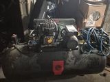un gros compresseur d'air installé dans une pièce encombrée de bric-à-brac