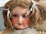 a doll that is sitting on a chair in a room