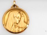 an image of a gold medal of a woman with a veil