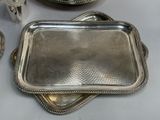 two silver trays sitting on a table next to each other