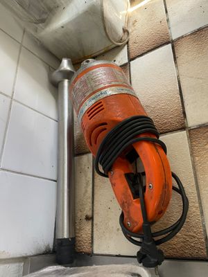 une photo d'une ponceuse à main orange dans une salle de bains