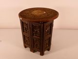 a small wooden table with intricate carvings on it