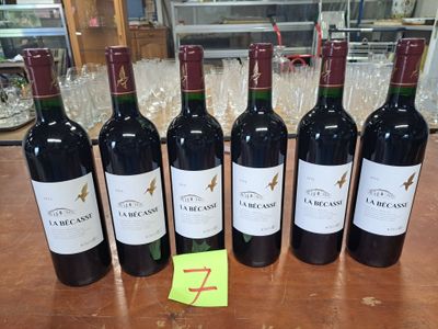 six bouteilles de vin rouge sont alignées sur une table