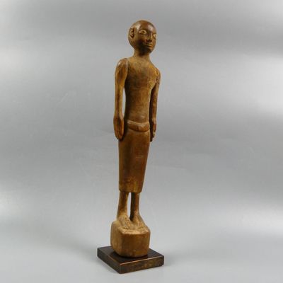 a wooden statue of a man standing on top of a wooden base
