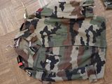 a camouflage bag sitting on the floor next to a pair of scissors