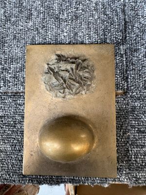 un gros plan d'un objet métallique sur lequel se trouve une boule dorée
