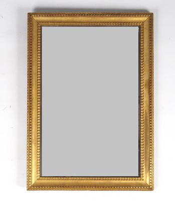 un miroir au cadre doré accroché à un mur blanc, à côté d'un autre mur blanc