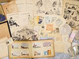 a lot of old books and postcards on a bed