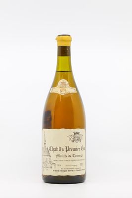 une vieille bouteille de vin posée sur une table blanche