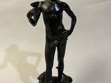 bronze statue of a boy holding a bird on a rock
