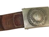une vieille ceinture avec une boucle métallique sur fond blanc
