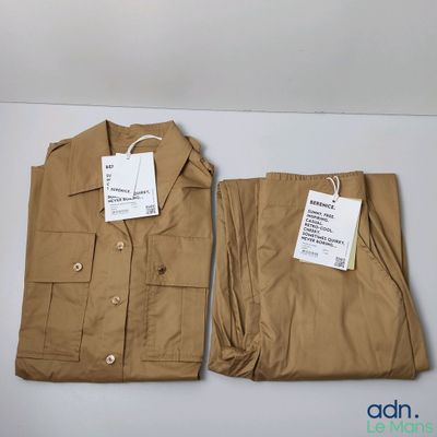deux pantalons kaki pour homme, encore étiquetés, posés sur une table