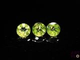 a pair of green peridots sitting on top of a black surface